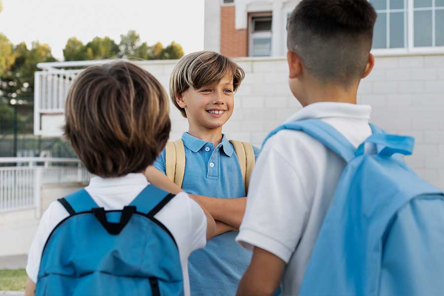 Hay tres niños estan saludando.