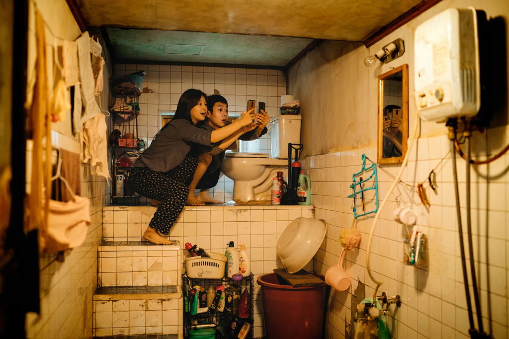 Un hombre y una mujer están en un baño, intercambiando teléfonos.
